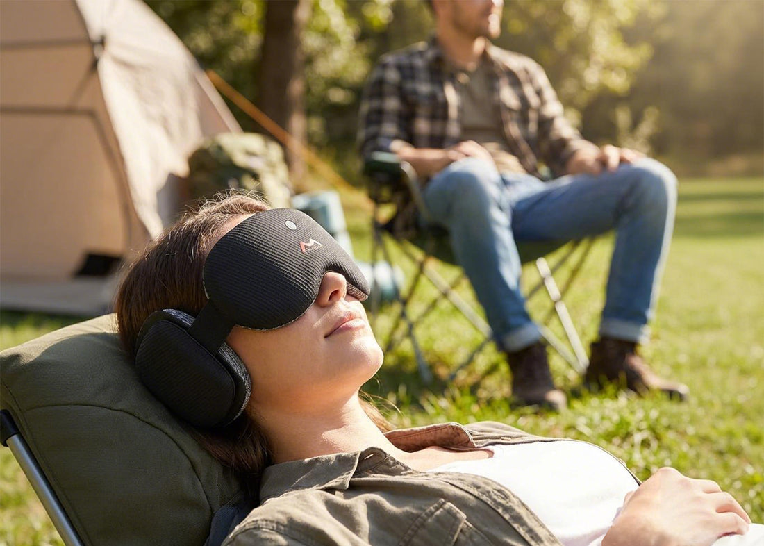 Woman resting outdoors with Fismool sound sleep mask black, enjoying quiet time while blocking light and ambient noise.