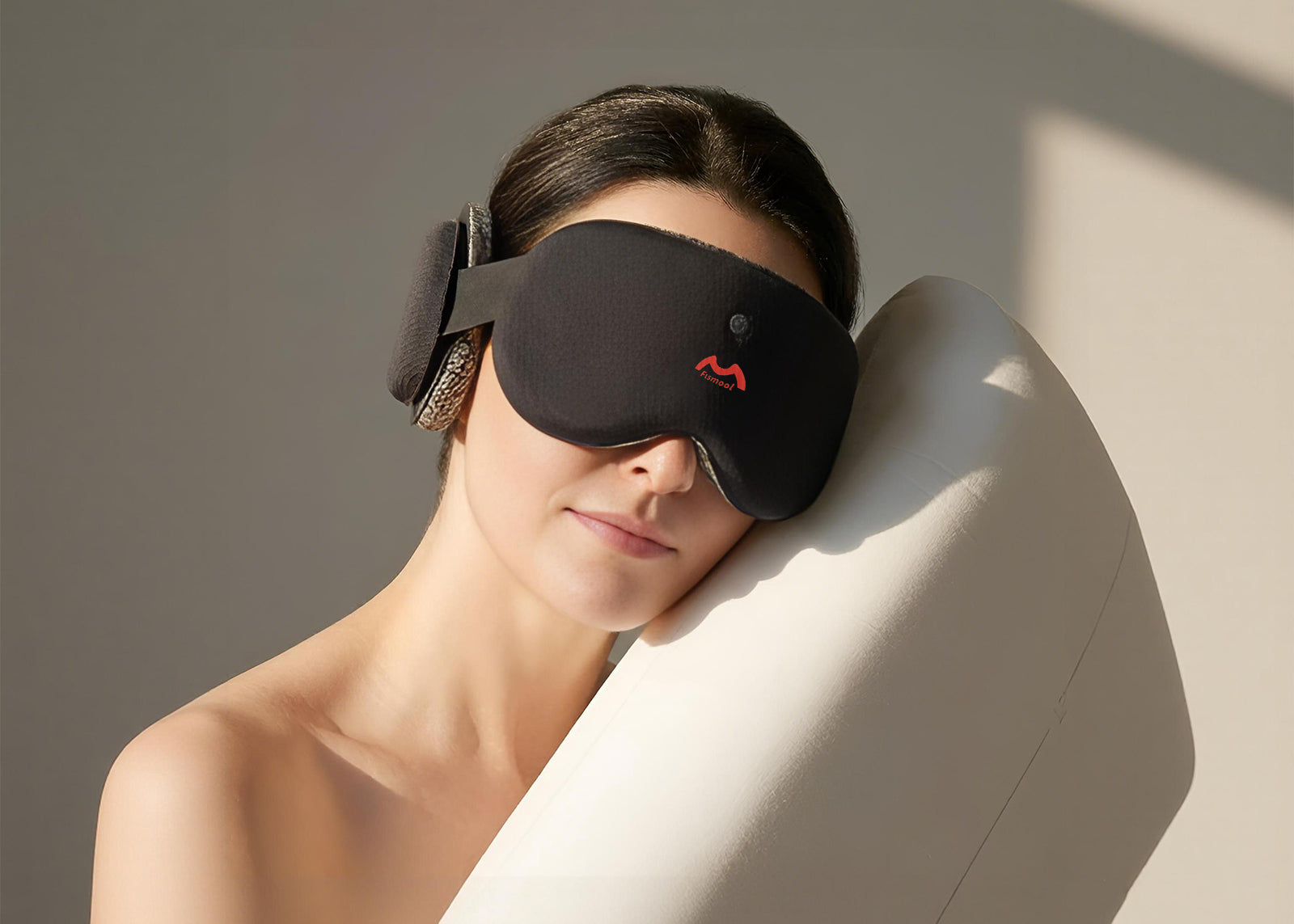 Person wearing a black Fismool sound sleep mask, leaning on a white pillow for side sleeping comfort