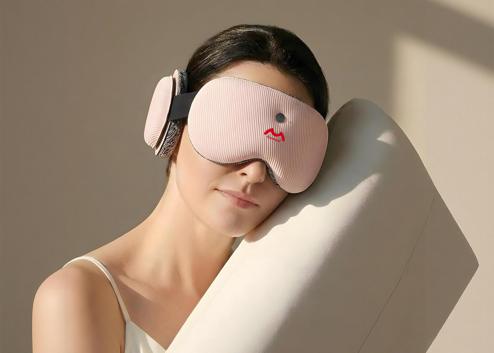 Person wearing a pink Fismool sound sleep mask, leaning on a white pillow for side sleeping comfort